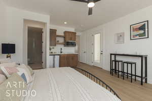 Bedroom featuring ensuite bath, ceiling fan, and light hardwood / wood-style flooring