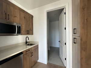 Kitchen with stainless steel appliances, sink, and light tile patterned floors