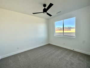 Carpeted empty room featuring ceiling fan