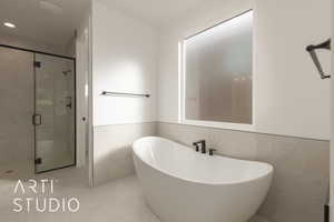 Bathroom with plus walk in shower and tile walls