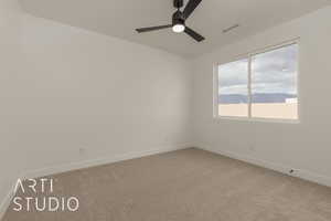 Carpeted empty room featuring ceiling fan