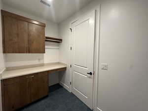 Laundry room featuring dark tile patterned flooring