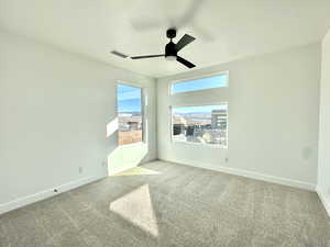 Unfurnished room featuring light carpet and ceiling fan