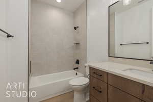 Full bathroom featuring vanity, hardwood / wood-style floors, tiled shower / bath combo, and toilet