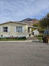 Manufactured / mobile home with a carport, a mountain view, and a storage unit