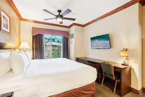 Bedroom with ornamental molding, carpet, and ceiling fan