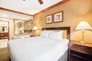 Bedroom featuring tile patterned flooring, ornamental molding, and ceiling fan