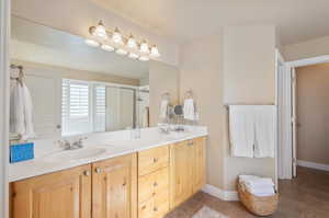 Bathroom featuring tile patterned floors, walk in shower, and vanity