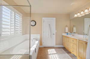 Bathroom featuring vanity, tile patterned floors, and a washtub