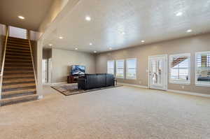 Unfurnished living room featuring a textured ceiling and carpet flooring