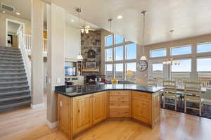 Kitchen featuring a notable chandelier, plenty of natural light, light hardwood / wood-style flooring, and a fireplace