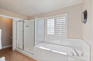 Bathroom featuring plus walk in shower and tile patterned floors