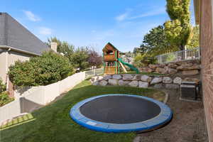 Exterior space featuring a trampoline, central AC, and a playground