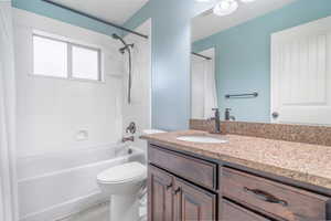 Full main bathroom with shower / tub combo, hardwood / wood-style flooring, vanity, and toilet