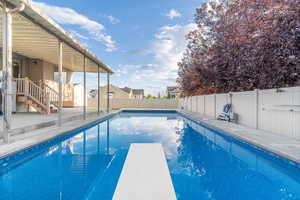 View of heated saltwater pool featuring a diving board