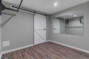 Workout room with mirrors and pull-up bar, barn door is access to cold storage.