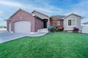 Single story home featuring a front yard and a garage