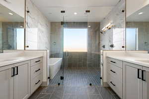 Bathroom featuring vanity, tile walls, and plus walk in shower