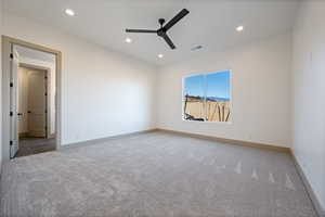 Carpeted empty room featuring ceiling fan