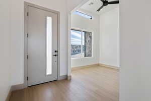 Foyer entrance with ceiling fan and light wood-type flooring