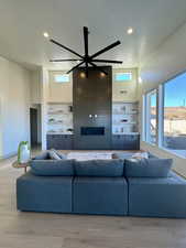 Living room featuring ceiling fan, a textured ceiling, and light wood-type flooring