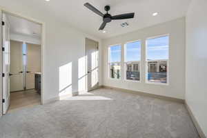 Carpeted spare room featuring ceiling fan