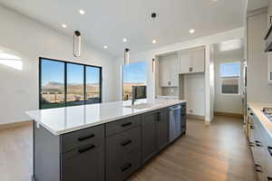 Kitchen featuring a wealth of natural light, a mountain view, gray cabinetry, and hanging light fixtures