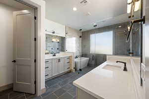 Bathroom featuring vanity, tile walls, and shower with separate bathtub