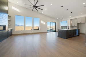 Kitchen featuring gray cabinets, an island with sink, and a healthy amount of sunlight