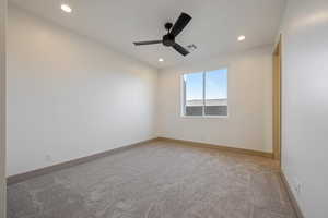 Carpeted spare room featuring ceiling fan