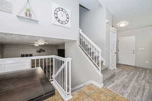 Stairway with a textured ceiling and hardwood / wood-style floors