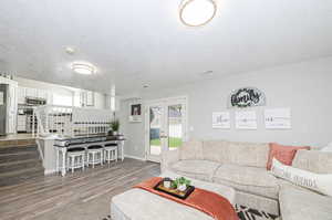 Living room with a textured ceiling and hardwood / wood-style flooring