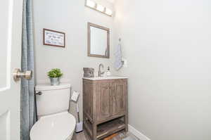 Bathroom with wood-type flooring, vanity, and toilet