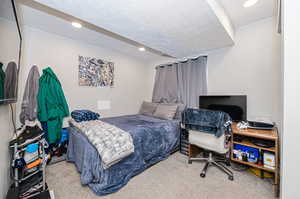 Carpeted bedroom with a textured ceiling