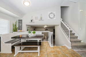 Dining room with vaulted ceiling, a textured ceiling, and ceiling fan