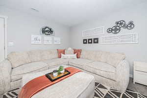 Living room with carpet floors and a textured ceiling