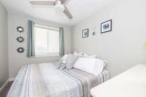 Bedroom featuring wood-type flooring, ceiling fan, and a textured ceiling