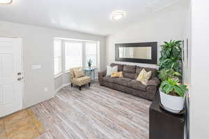 Living room featuring a textured ceiling, light hardwood / wood-style flooring, and vaulted ceiling