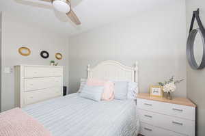 Bedroom with ceiling fan and a textured ceiling