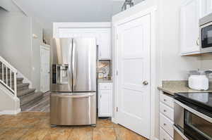 Kitchen with stainless steel appliances and white cabinetry