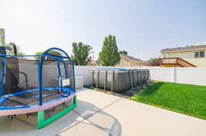 View of patio / terrace featuring a fenced in pool and a trampoline