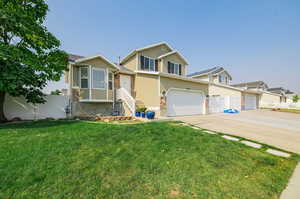 View of front of property featuring a front yard and a garage