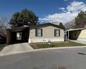 Manufactured / mobile home with driveway and a carport