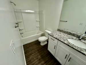 Full bathroom featuring vanity, bathtub / shower combination, toilet, and hardwood / wood-style flooring