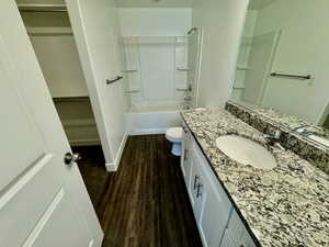 Full bathroom featuring bathtub / shower combination, hardwood / wood-style floors, vanity, and toilet