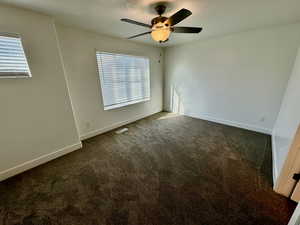 Carpeted empty room featuring ceiling fan