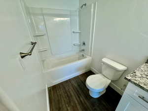 Full bathroom with vanity,  shower combination, hardwood / wood-style floors, and toilet