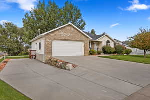 Single story home with a garage and a front lawn