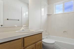 Full bathroom featuring tub / shower combination, vanity, and toilet