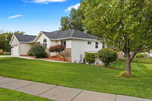 View of front facade featuring a front lawn and a garage